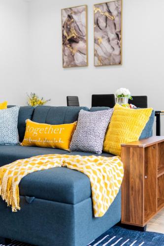 a blue couch with pillows on it in a living room at Cozy Modern 3BR Houston Townhome in Houston