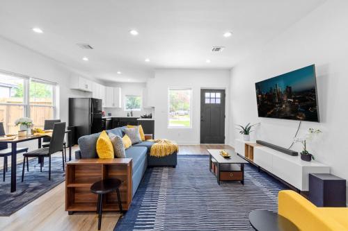 a living room with a blue couch and a kitchen at Cozy Modern 3BR Houston Townhome in Houston