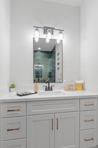 a white bathroom with a sink and a mirror at Cozy Modern 3BR Houston Townhome in Houston