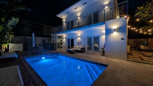 a swimming pool in front of a house at night at Inn On The Drive in Fort Lauderdale
