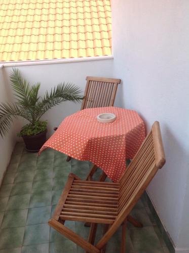 a table and chairs with a red and white polka dot table cloth at Ana Tudor Apartments in Hvar