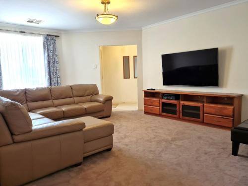 a living room with a couch and a flat screen tv at Moonta Bay Getaway in Port Moonta