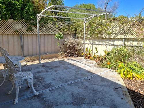 a patio with two chairs and a pergola at Moonta Bay Getaway in Port Moonta