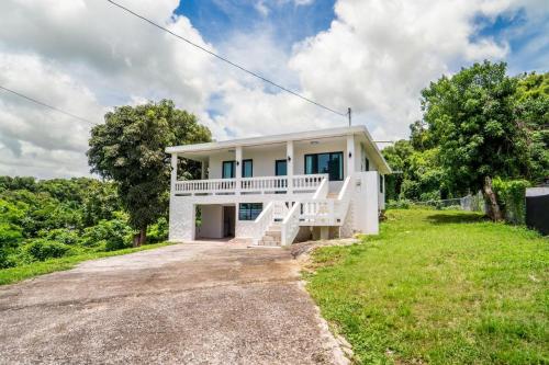 a large white house on a hill with trees at Casa Kairo in Vega Baja