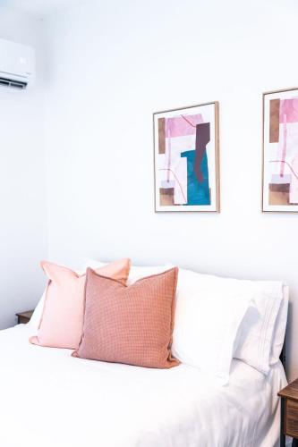 a white bed with pink pillows in a bedroom at Casa Kairo in Vega Baja