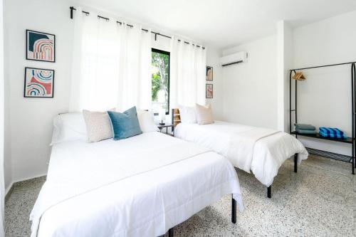 two beds in a room with white walls at Casa Kairo in Vega Baja