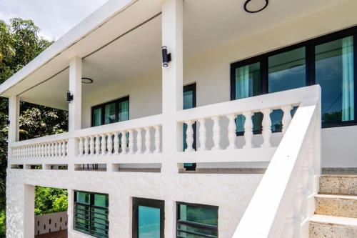 a white house with black windows and a staircase at Casa Kairo in Vega Baja