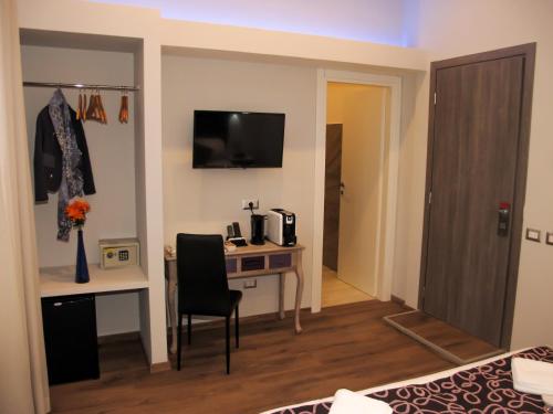 a hotel room with a desk and a bedroom at Roma Veneto Relais in Rome