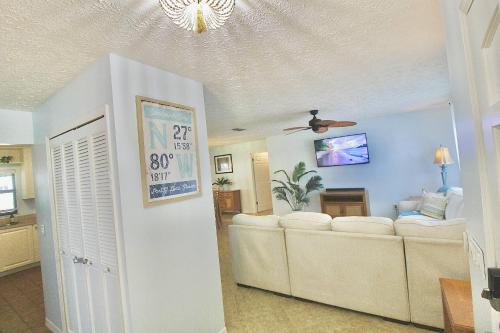 a living room with a couch and a ceiling at Sandpiper Stay in Port Saint Lucie