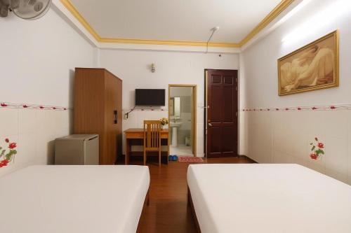 a room with two beds and a table in it at Diamond Hotel CMT8 - Center SaiGon in Ho Chi Minh City