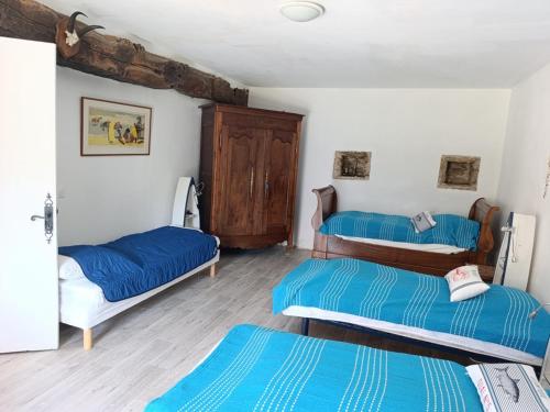 - 2 lits dans une chambre avec des draps bleus dans l'établissement Charmante Longère Bretonne au Calme, Proche Mer - FR-1-639-135, à Sarzeau