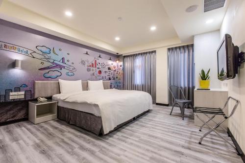 a hotel room with a bed and a desk and a tv at The Cloud Hotel Zhongli Branch in Zhongli