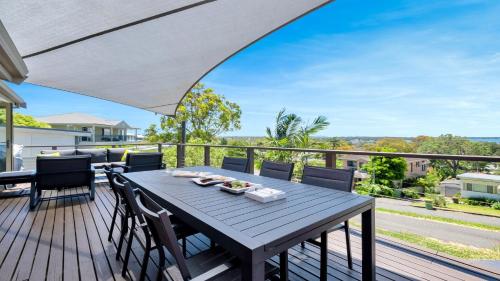 a wooden deck with a table and chairs on a balcony at Aquavista Beach, Lake, Sun, and Sand in Budgewoi