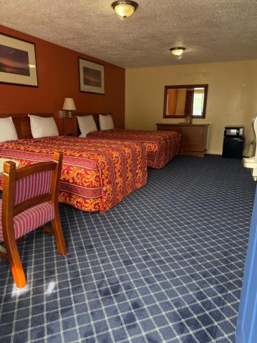a hotel room with a bed and a chair at American Star Inn & Suites Atlantic City in Galloway