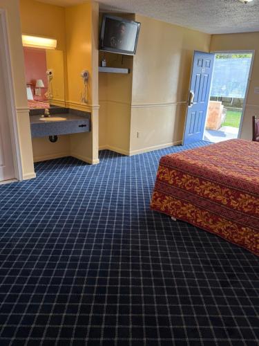 a hotel room with a bed and a sink at American Star Inn & Suites Atlantic City in Galloway