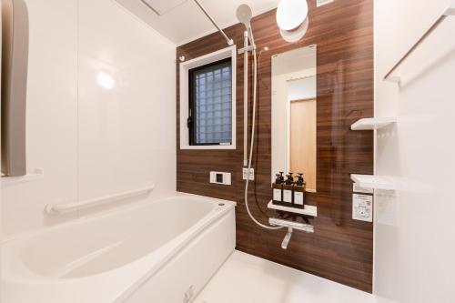 a bathroom with a white tub and a sink at 70sqm Private House, Major Tokyo Spots & Free Parking in Tokyo