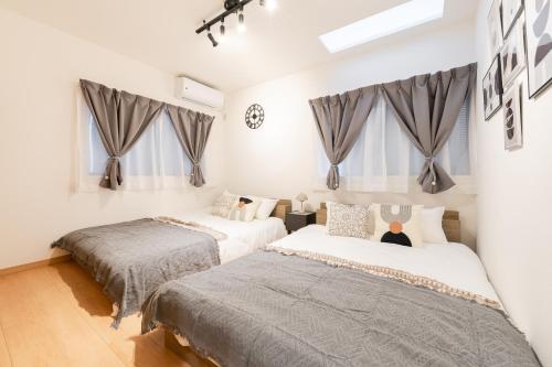 two beds in a white room with windows at 70sqm Private House, Major Tokyo Spots & Free Parking in Tokyo