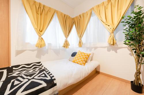 a bedroom with a bed and a window with curtains at 70sqm Private House, Major Tokyo Spots & Free Parking in Tokyo