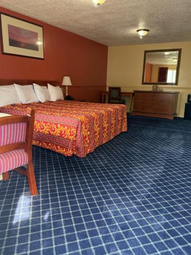 a hotel room with a bed and a chair at American Star Inn & Suites Atlantic City in Galloway