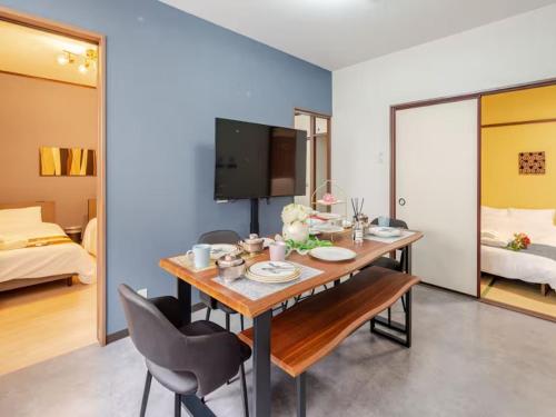 a dining room with a table and chairs and a bedroom at 402 Newly opened Hotel Baika Family friendly Free parking 10 minutes to USJ in Osaka