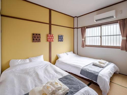 a room with two beds and a window at 402 Newly opened Hotel Baika Family friendly Free parking 10 minutes to USJ in Osaka