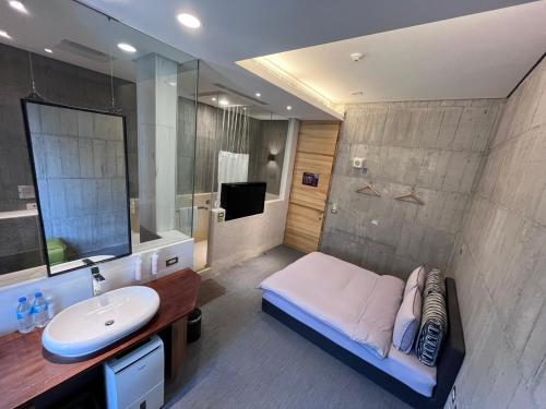 a bathroom with a bed and a sink and a mirror at Smoking Rock in Jiaoxi
