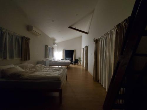 a hallway with two beds in a room at ヴィラ竜宮城鳩間 in Taketomi