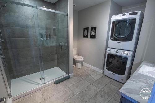 a bathroom with a shower and a washing machine at Rois de la Montagne - Condo vue sur golf in Saint-Jean-de-Matha