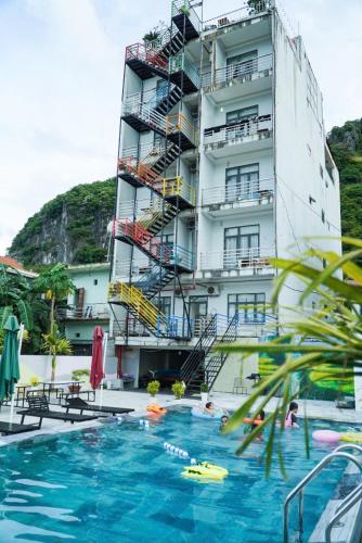 a building with a swimming pool in front of a building at Phong Nha Jasmine Hostel & Roof Top Bar in Phong Nha
