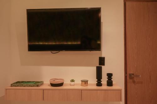 a flat screen tv sitting on top of a cabinet at Macondo Quinta Avenida Residences in Playa del Carmen