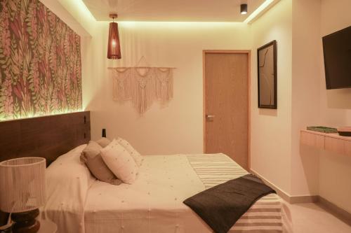 a bedroom with a large white bed in a room at Macondo Quinta Avenida Residences in Playa del Carmen