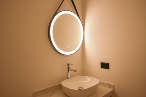 a bathroom with a sink and a mirror on the wall at Macondo Quinta Avenida Residences in Playa del Carmen