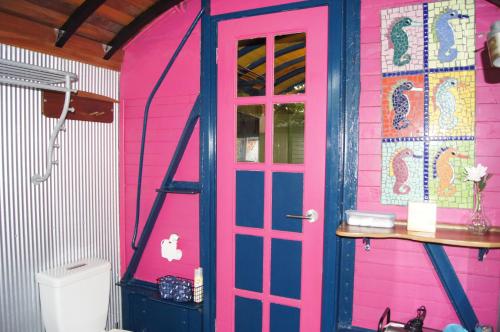 ein rosa und blaues Haus mit einer Tür und einer Toilette in der Unterkunft South Terrace Studio - Walk to Everything ! in South Fremantle