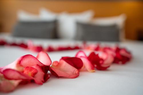 a group of red rose petals on a table at Chateau Royal Beach Resort & Spa, Noumea in Noumea