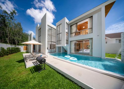 an exterior view of a house with a swimming pool at 4BR Private Pool Villa near Laguna & Beach - Lux Pride 2 by Warm Plus in Ban Pak Lak