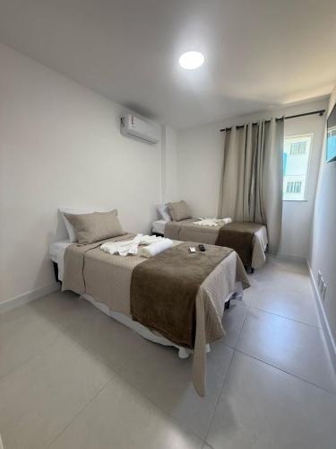 a bedroom with two beds and a window at Arraial do Cabo RJ - Golden Lake in Arraial do Cabo