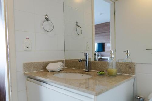 Un mostrador de baño con un lavabo y un espejo. en V903 Apart área central com vista para esplanada, en Brasilia