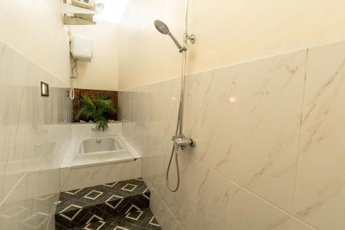 un bagno con doccia e lavandino di Pondok Manik Uma a Tabanan