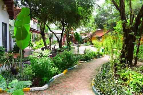 ein Garten mit einem Ziegelweg und Bäumen und Pflanzen in der Unterkunft Trang An Ecorest Resort & Spa in Xuân Sơn