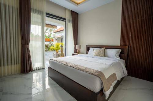 una camera da letto con un letto grande e una grande finestra di Pondok Manik Uma a Tabanan