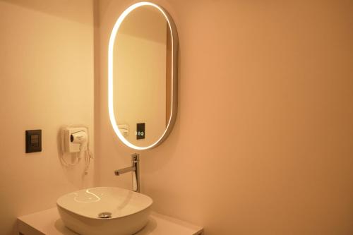 a bathroom with a white toilet and a mirror at Macondo Quinta Avenida Residences in Playa del Carmen