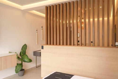 a room with a bed and a wooden wall at Macondo Quinta Avenida Residences in Playa del Carmen