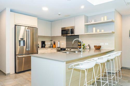 a kitchen with white cabinets and stainless steel appliances at Elan at Ballena Beach in Uvita