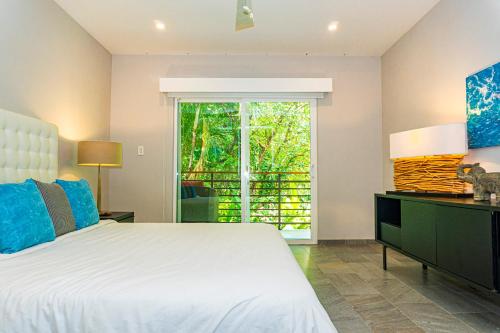 a bedroom with a white bed and a window at Elan at Ballena Beach in Uvita