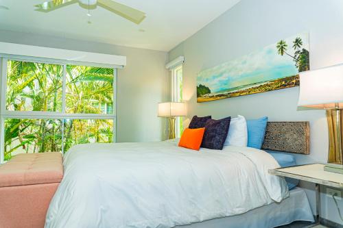 a bedroom with a white bed and a window at Elan at Ballena Beach in Uvita