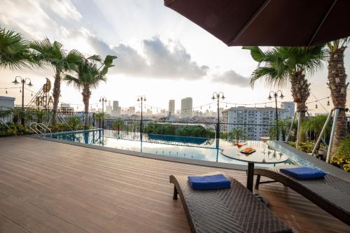 a balcony with a table and chairs and palm trees at FTE Ba Dinh Hotel in Hanoi