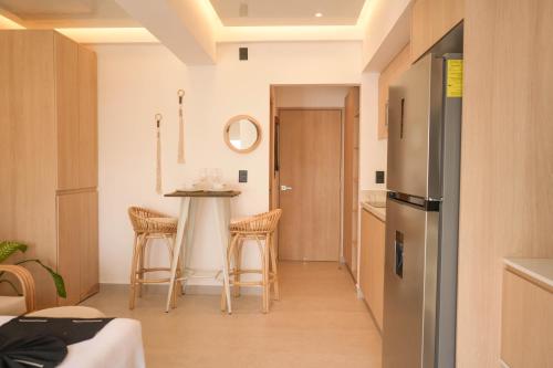 a kitchen with a table and stools in a room at Macondo Quinta Avenida Residences in Playa del Carmen