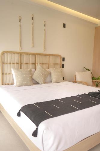 a large white bed with a black blanket on it at Macondo Quinta Avenida Residences in Playa del Carmen