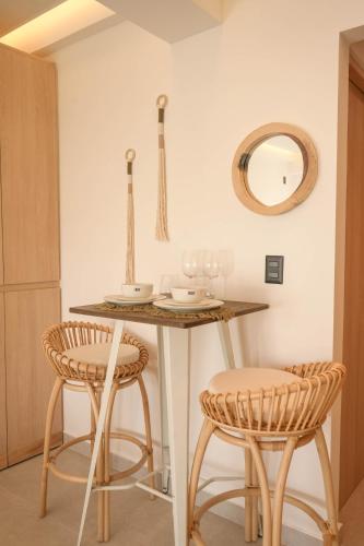 a kitchen with a table with two chairs and a mirror at Macondo Quinta Avenida Residences in Playa del Carmen