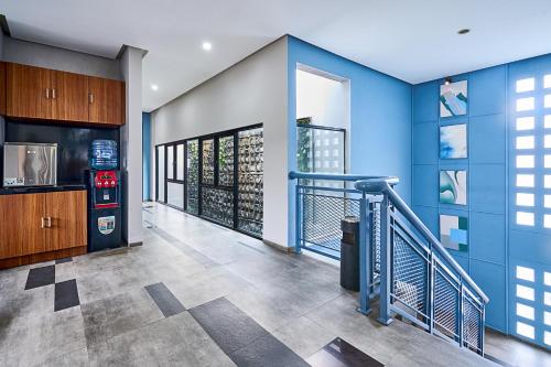 a room with a blue wall and a stairway at Bale Resident in Jakarta